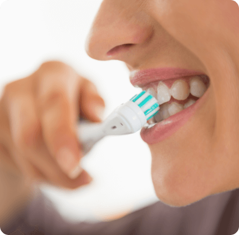 Close up of person smiling while brushing their teeth