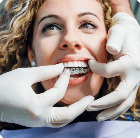 Dentist placing Invisalign aligner over a patient's teeth