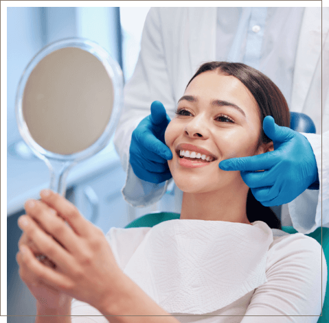 Dental patient looking at her smile in mirror after preventive dentistry
