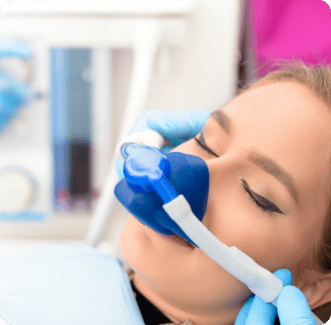 Young woman with eyes closed in dental chair wearing nitrous oxide mask